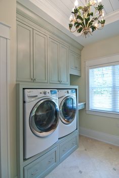 a washer and dryer in a very large room with white trim on the walls