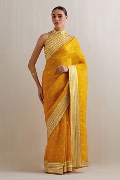 Mango yellow saree with aari, sequin, zari embroidery. Paired with halter neck embroidered blouse and petticoat. - Aza Fashions Transitional Gold Pre-draped Saree With Gota Work, Yellow Pre-draped Saree With Resham Embroidery, Yellow Bollywood Pre-draped Saree, Yellow Bollywood Traditional Wear For Transitional Season, Yellow Raw Silk Traditional Wear With Mirror Work, Yellow Traditional Wear With Mirror Work In Raw Silk, Transitional Gold Saree With Dori Work, Bollywood Style Yellow Pre-draped Saree For Navratri, Yellow Bollywood Pre-draped Saree For Navratri