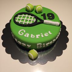 a green cake with tennis balls and a racquet on it's side