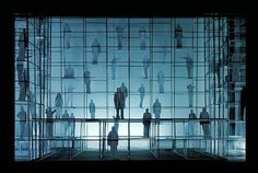 silhouettes of people standing in front of a glass wall with multiple rows of windows