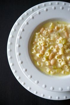 a white bowl filled with macaroni and cheese soup on top of a table