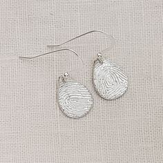 Keep your loved one with you always, with these lovely teardrop fingerprint earrings. Handcrafted in solid sterling silver, these earrings feature a beautiful teardrop design that is stylish, yet simple. Your earrings can be made with the same fingerprint on both teardrops or they can be made with a different fingerprint on each earring. The teardrops hang from sterling silver ear wires. The intricate details of your fingerprint are captured with exceptional precision using my perfected techniqu Thumbprint Jewelry, Thumb Print, Thumb Prints, Fingerprint Jewelry, Printed Jewelry, Baby Memories, Memorial Keepsakes, Small Heart, Earrings Sterling Silver