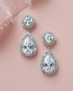 The epitome of classic bridal beauty, our Allure CZ Wedding Earrings are designed with CZs surrounded by a halo of delicate stones that sparkle & shine like real diamonds. Perfect for brides & bridesmaids. Available in silver, these earrings are surprisingly lightweight for easy day to night wear. Wedding Cubic Zirconia Earrings With Diamond Accents, Classic Crystal Earrings With Diamond Accents For Wedding, Classic Wedding Crystal Earrings With Cubic Zirconia, Classic Cubic Zirconia Bridal Earrings For Wedding, Classic Diamond Crystal Earrings For Wedding, Classic Cubic Zirconia Diamond Earrings For Wedding, Diamond Teardrop Earrings With Sparkling Stones For Wedding, Wedding Teardrop Diamond Earrings With Diamond Accents, Classic Sparkling Diamond Earrings For Wedding