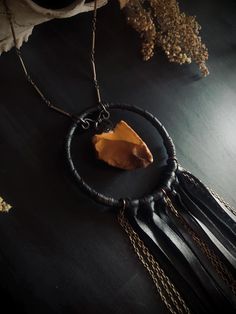 This necklace features a beautiful piece of jasper I found in Oregon a few summers ago. The waxy stone has been polished only by the lake bed it was collected from and has been given an electroformed copper hook. It's vibrant burnt orange color creates a striking contrast next to the black leather. The stone is encircled by a 3 inch wide leather wrapped copper hoop and 8 inches of lengthy leather fringe and brass chains. The stone's connector links are copper while the necklace portion is made u Bohemian Brown Electroformed Necklaces, Bohemian Agate Necklace With Raw Stone, Bohemian Agate Raw Stone Necklace, Hand-wrapped Jasper Pendant Necklace, Hand Wrapped Jasper Pendant Necklace, Spiritual Electroformed Amber Necklace, Spiritual Hand Forged Brown Necklace, Bohemian Amber Hand Wrapped Necklace, Bohemian Hand Wrapped Amber Necklace