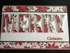 a christmas card with the word merry written in red and green flowers on white paper