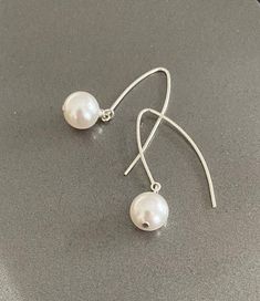 "Large white Swarovski crystal pearl drop dangle arc earrings are available in gold filled or sterling silver. Lightweight, minimalist & modern. A great addition to any outfit dressed up or down, day to evening. They go with everything.  The earrings are appox 1.5\" from end to end.   You may also like to check out more of my pearl jewelry and June birthstone gift ideas here: https://etsy.me/3olEKFI You may also like to check out more of my earrings here: http://etsy.me/2oDJlWy Free first class USPS shipping within the USA." Pearl Dangle Earrings, Jewelry Words, June Birthstone, Pearl Earrings Dangle, Swarovski Pearls, Gold Earrings Dangle, June Birth Stone, Silver Earrings Dangle, Crystal Pearls