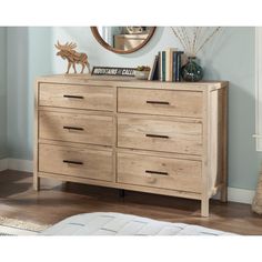 a wooden dresser sitting on top of a hard wood floor next to a mirror and rug