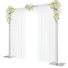 a white wedding arch decorated with flowers and greenery