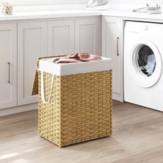 a laundry basket sitting next to a washer and dryer in a white kitchen