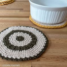 a crocheted coaster sits on the floor next to a bowl