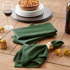 the napkins are laying on the table next to the wine bottle