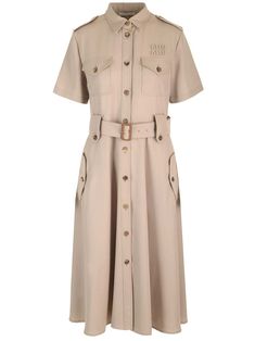 Midi dress in light brown wool gabardine from Miu Miu, with buttons along the entire length, short sleeves, chest and side pockets with flap, flared midi skirt. Luxury Miu Miu Skirt For Workwear, Miu Miu Fitted Formal Dresses, Elegant Spring Miu Miu Dresses, Formal Fitted Miu Miu Dresses, Elegant Miu Miu Dresses For Spring, Chic Summer Miu Miu Dresses, Beige Knee-length Shirt Dress For Workwear, Brown Midi Dress With Button Closure For Work, Khaki Short Sleeve Midi Dress