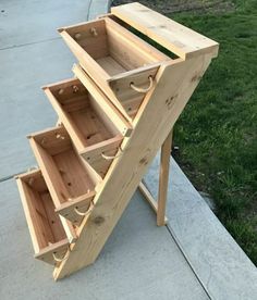 a wooden table with drawers on it sitting in front of a grass covered yard and sidewalk