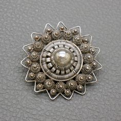 "A wonderful quality antique star-shaped Dutch Button sterling silver filigree pin with lots of character. This Victorian style brooch is hand crafted Holland in in early 1900's in old filigree technique, so called Zeeuwse Knoop (\"Dutch button\"). A collectible piece of traditional Dutch heritage jewelry! The brooch will be shipped in a gift box. The brooch measures almost 1 1/2 inches (3.6 cm) in diameter Weight: 7.7 grams Original trombone clasp closure The brooch was professionally tested fo Traditional Dutch Jewelry, Antique Filigree Brooches For Ceremonial Occasions, Ornate Filigree Pendant Brooch, Vintage Filigree Brooches For Ceremonial Occasions, Vintage Ceremonial Filigree Brooches, Ornate Filigree Brooches For Ceremonial Use, Ceremonial Vintage Filigree Brooches, Victorian Round Brooches With Intricate Design, Vintage Filigree Pendant Brooch