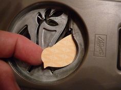 a person is pressing the button on an automatic water heater with a piece of wood sticking out of it