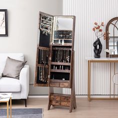 a living room filled with furniture and a tall wooden shelf next to a white couch