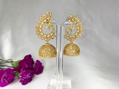 *Jhumki with peacock design and polki stones *Detailed with small gold pearls. *Light weight. *Earrings are 1.25 inches wide at the widest point of the earrings, and 2.75 inches long from the base of the earring to the end of the dangling beads. *Items are made with an alloy of metals, most commonly a blend of nickel, zinc and copper. *For any questions e-mail adorn.jewelry.us@gmail.com Peacock Design Jhumkas For Diwali Wedding, Peacock Design Jhumkas For Wedding And Diwali, Wedding Jhumkas With Peacock Design For Diwali, Gold Kundan Chandbalis With Peacock Design, Elegant Kundan Jhumkas With Peacock Design, Gold Kundan Jhumkas With Peacock Design, Gold Chandbali Jhumkas With Peacock Design, Gold Peacock Design Jhumkas For Festive Season, Gold Bollywood Jhumkas With Peacock Design