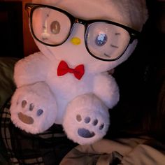 a white teddy bear wearing glasses and a bow tie