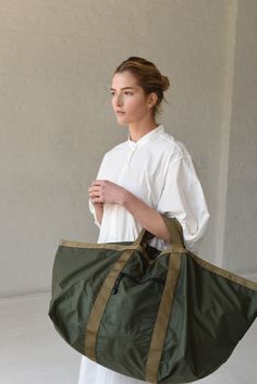 a woman carrying a large green and tan bag