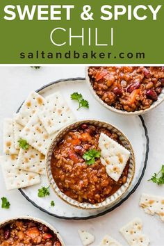 two bowls filled with chili and crackers on top of a white plate next to the bowl