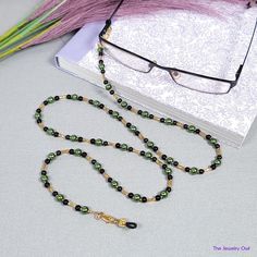 This jade green and black beaded chain will keep your glasses within reach, while adding a pop of color to your look. Just attach it to your glasses and you can have the peace of mind that your glasses will be with you wherever you go! The perfect gift for those who tend to misplace their glasses. Rubber loops adjust to fit most glasses frames. Lightweight and comfortable fit.   🦉Product Details:  * Approx. Length - 31 in (including rubber loops) * Chain Weight: 0.7 oz * Bead Color(s): Jade Green, Black, Gold * Metal Color: Gold-tone * Material: Glass pearls and Beads, bugle Beads * Closure: Lobster Claw Clasps and Rubber Loop Ends * Product ID: G171 🎁 Gift packaging available at Checkout ($4.00 USD) - See last image   🦉NOTES: * Not recommended for young children! * The lobster clasps m Black Glass Beaded Necklaces With Beaded Chain, Black Glass Beaded Necklace With Beaded Chain, Black Beaded Glasses Chains As Fashion Accessory, Black Glass Beaded Necklace, Black Beaded Glasses Chains For Fashion, Handmade Green Glasses Chains With Round Beads, Black Beaded Glasses Chain With Round Beads, Black Beaded Glasses Chains, Green Round Beaded Glasses Chains For Gifts