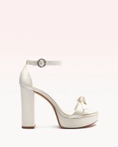 For the bride seeking an elevated lift, the Clarita Platform heel provides glamorous height with its 120mm block heel and platform, while remaining comfortable for day-to-night wear. Crafted in our light-reflected silver metallic leather, this eye-catching style is finished with our signature Clarita bow and an ankle-s Quince Heels, Wedding Shoes Platform, Ivory Bridal Shoes, White Platform Sandals, Wedding High Heels, Latest Sandal, Wedding Shoes Bride, White High Heels, Beautiful High Heels