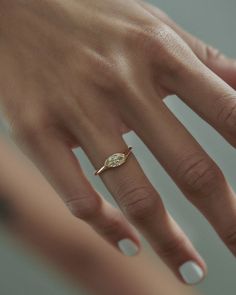 a woman's hand with a diamond ring on it