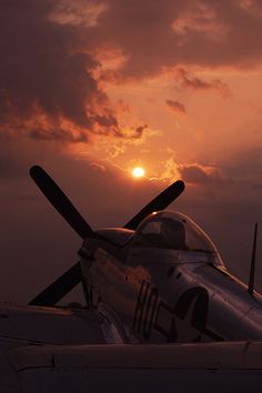 the sun is setting behind an airplane on the tarmac with it's propeller still attached