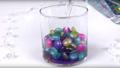 a glass filled with lots of colorful candy