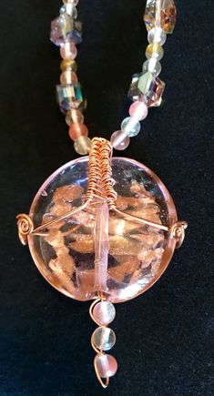 "Awesome Large Glass Pink and Copper Focal Bead Wire Wrapped in Copper with Tourmaline and Pink Glass AB Beads (Aurora Borealis) and Earrings to Match.  The focal bead is bound in copper wire.  Earrings to match made of bent copper wire and beads from the necklace in a creative drop, 3 1/4\" long, very lightweight.  The extra large handmade silver ear wires are wrapped in copper. Copper S-Clasp.  * Large Light Pink/Purple Glass Focal bead with Copper inside * Copper Wire Wrapping * Earrings to M Iridescent Beaded Round Bead Jewelry, Handmade Iridescent Jewelry With Round Beads, Iridescent Beaded Jewelry As A Gift, Handmade Iridescent Round Bead Jewelry, Iridescent Beaded Jewelry For Gift, Iridescent Round Beaded Jewelry, Bohemian Iridescent Round Bead Jewelry, Gift Jewelry With Colorful Beads, Round Crystal Necklaces With Large Beads For Gifts