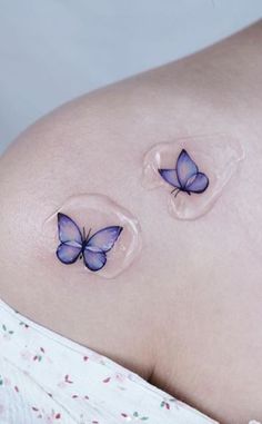 a pregnant belly with two butterflies on it's side, and the bottom part of her stomach