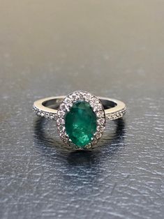 DeKara Designs Collection Our latest design! An elegant and lustrous Colombian Emerald surrounded by beautiful diamonds in a halo setting. Metal- 14K White Gold, .583. Stones- 1 Oval Colombian Emerald 1.25-1.40 Carats, 40 Round Diamonds, F-G color VS clarity, 0.30 carats. Latest of my creations. A beautiful Oval Colombian Emerald Halo Diamond Ring. The Emerald is a beautiful green and it is professionally prong set in between four double prongs. There are ten pave set round diamonds on each side Oval Emerald Ring In 14k White Gold, Luxury Oval Emerald Cluster Ring, Exquisite Oval Emerald Ring In Platinum, Luxury Oval Emerald Ring With Brilliant Cut, Elegant Oval Platinum Emerald Ring With Halo Setting, Formal Emerald Ring With Halo And Round Cut, Oval Emerald Ring With Diamond Accents, Oval Emerald Ring With Halo Setting In Platinum, Oval Emerald Ring In White Gold With Diamond