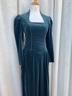 "Vintage Laura Ashley Romantic Victorian Style turquoise/teal Velvet long dress with long sleeves and side zipper closure. Corset style top. The dress is in a great condition, minor tear on left armpit, easily fixable by skilled seamstress. Marked size 6, see measurements below for proper fit.   Measurements (flat): Shoulder to shoulder: 15\" Sleeve length: 22\" Armpit to armpit: 16\" Waist: 28\" Skirt length: 31\" Overall length: 51\"" Green Fitted A-line Long Sleeve Dress, Fitted A-line Long Sleeve Winter Dress, Fitted Long Sleeve A-line Dress For Winter, Long Sleeve Dress With Fitted Bodice, Green Long Sleeve Dress With Fitted Bodice, Winter Dresses With Long Sleeves And Back Zipper, Fitted A-line Long Sleeve Dress For Fall, Fitted A-line Long Sleeve Dress For Winter, Winter Dresses With Fitted Bodice And Long Sleeves