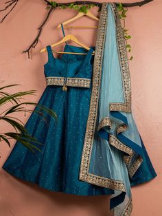 This is a three-piece Peacock Blue lehenga set with sky blue dupatta from the Anisha Shetty collection. This beautiful peacock blue rawsilk stone work lehenga is paired with a raw silk peacock blue embroidered blouse. The peacock blue color with stone work and embroidery enhances this lehenga set. The blouse has a sequin tassel tie-up at the back. The outfit is completed with a net sky blue dupatta with heavy gold embroidery border in peacock blue accent and badla work all over. Blue Raw Silk Saree Dress, Designer Turquoise Choli For Festive Occasions, Blue Lehenga For Festive Occasions, Designer Festive Turquoise Choli, Festive Blue Lehenga For Festivals, Blue Floor-length Festive Choli, Bollywood Style Turquoise Sets For Reception, Turquoise Bollywood Sets For Reception, Bollywood Turquoise Sets For Reception