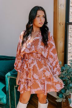 - Move into your boho babe era with this gorgeous dress! - Lightweight material with a pink hued floral print - A v-cut neckline - Long, oversized sleeves - A stretchy smocked waistline - A tiered skirt with a built-in lining - A flowy yet flattering silhouette that ends in a mid-thigh length hemline Pink Floral Print Boho Dress For Day Out, Pink Floral Boho Dress For Day Out, Long Sleeve Boho Dress With Floral Print For Brunch, Flowy V-neck Floral Dress, Bohemian Floral V-neck Dress For Brunch, Brown Floral Print Mini Dress For Brunch, Flowy V-neck Floral Printed Dress, Brown Floral Print Mini Dress For Vacation, Chic Boho Dress With V-neck And Floral Print