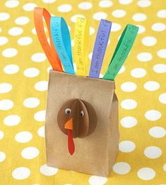 a paper bag with a turkey head on it and colorful forks sticking out of it