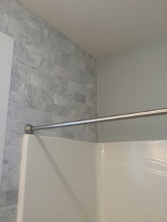 a white bath tub sitting inside of a bathroom next to a shower head mounted on a wall