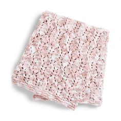 a pink crocheted blanket on top of a white surface