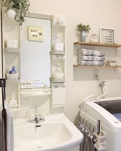 a washer and dryer sitting next to each other in a room with shelves on the wall