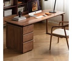 a desk with a computer on top of it in front of a bookshelf