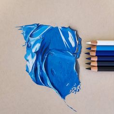 colored pencils next to a drawing of a blue piece of art