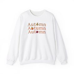 Get cozy in our Gildan 18000 sweatshirt, featuring a unique fall-themed design! The word 'Autumn' is repeated three times in vibrant orange, each word creatively incorporating a seasonal icon--a leaf, a scarecrow, and a pumpkin--into the lettering. This soft, durable sweatshirt is perfect for layering as the temperatures drop. Show off your love for the autumn season with this eye-catching, comfortable piece that celebrates all the best parts of fall." Ideal for any situation, a unisex heavy ble Relaxed Fit T-shirt With Ribbed Cuffs For Fall, Casual Sweater With Graphic Print For Fall, Orange Letter Print Crew Neck Hoodie, Fall T-shirt With Ribbed Cuffs And Relaxed Fit, Fall Relaxed Fit T-shirt With Ribbed Cuffs, Fall Crew Neck Sweater With Graphic Print, Fall Graphic Print Crew Neck Sweater, Fall Graphic Print Long Sleeve Sweatshirt, Trendy White Sweatshirt For Fall