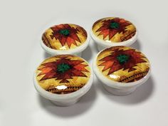 four decorative ceramic knobs with designs on them sitting next to each other in front of a white background