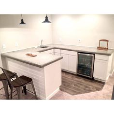 an empty kitchen with white cabinets and gray counter tops