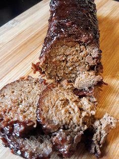 sliced meatloaf sitting on top of a wooden cutting board