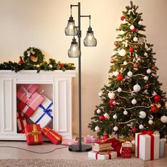 a christmas tree with presents under it next to a fireplace