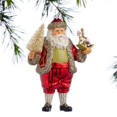 a glass ornament with a santa clause holding a christmas tree and a bell