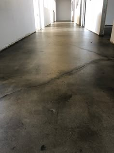 an empty hallway with white walls and doors