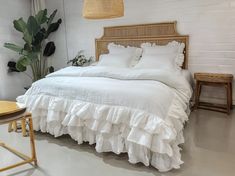 a bed with white sheets and ruffled bedspread