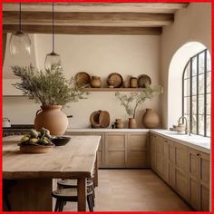 a wooden table sitting in front of a window next to a counter top with vases on it